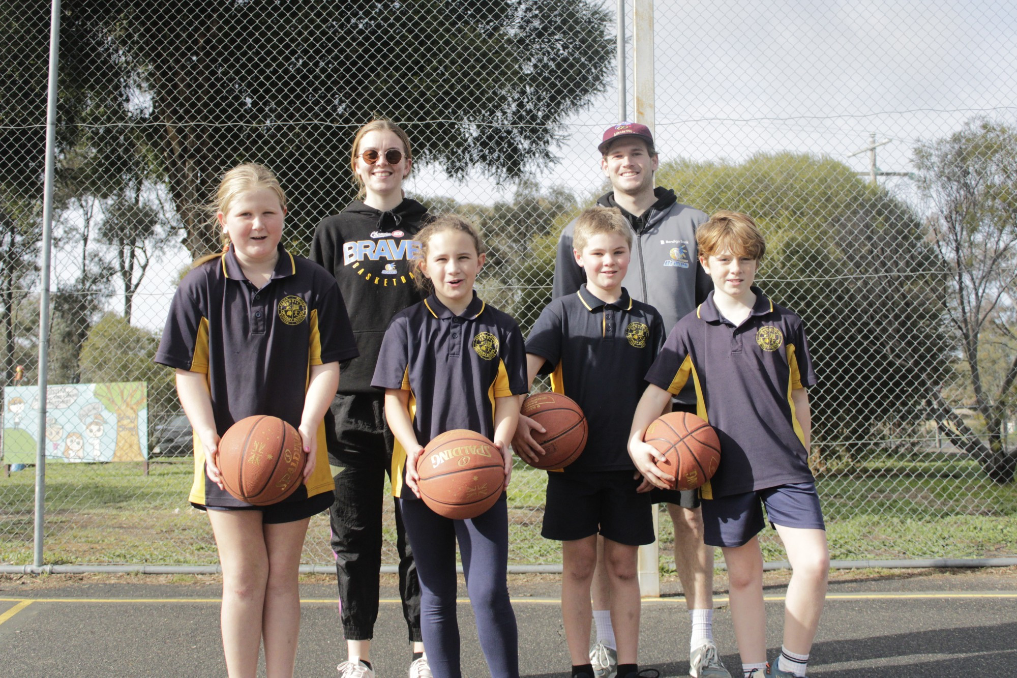 Dunolly Primary School students Grace, Taylah, Brayden and Billy with Bendigo Braves players Abbey Wehrung and Mitch Clarke as part of the school’s basketball program.