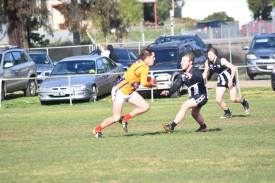 Dunolly’s Bailey Goodwin gets around Maryborough Rovers’ Mitch Whelan for a shot at goal.