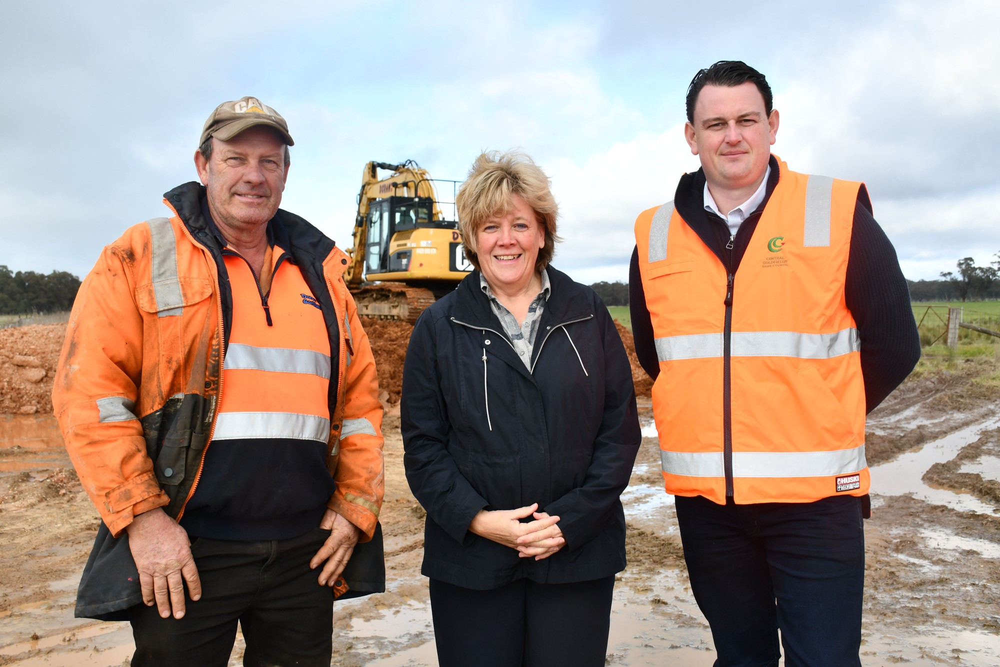 Doran Earthmoving manager Craig Doran, Tullaroop Ward councillor Anna De Villiers and Central Goldfields Shire Council manager infrastructure assets and planning Matthew Irving, with stage four flood levee works underway in the background.