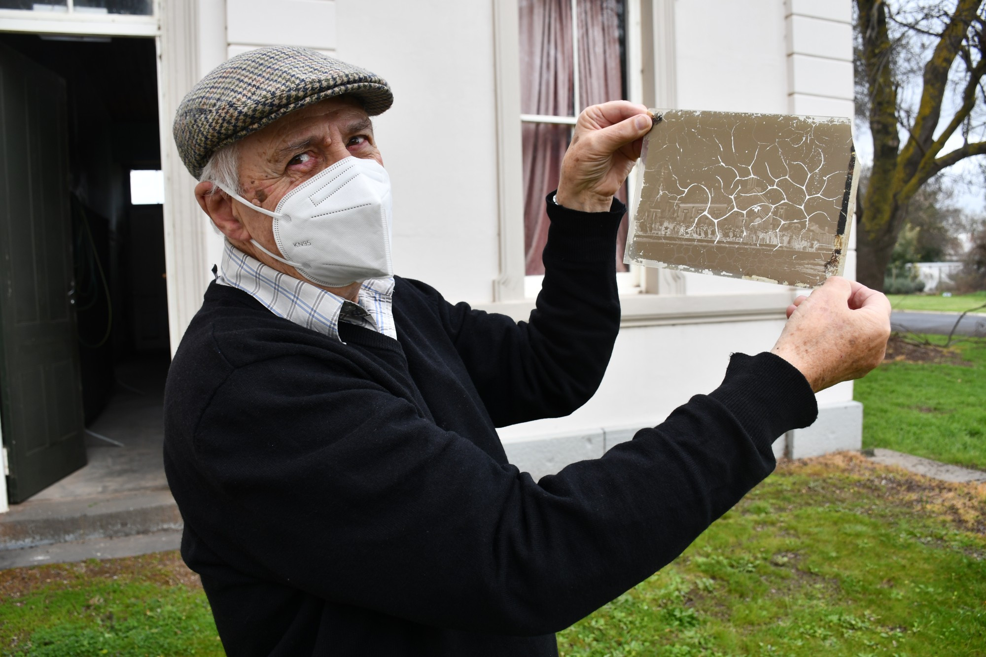 Carisbrook Historical Society member Alex Stoneman holding one of the glass negative plates, which dates back to 1866.