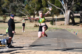 Cassidy Miller glides through the air in long jump. 