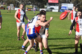 Trentham’s Ryan Bourke handpasses when tackled by Avoca’s Bryce Howell.