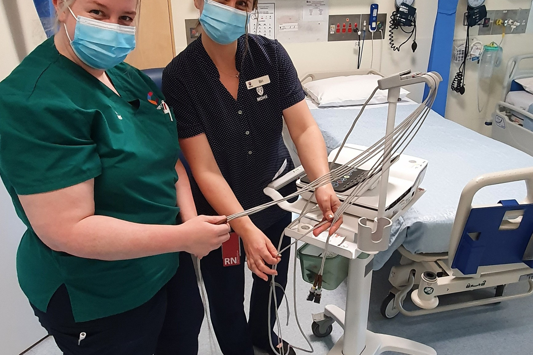 Nurse educator Bri Anderson takes Diploma of Nursing student Tiarne Gale through the set-up for an electrocardiogram.