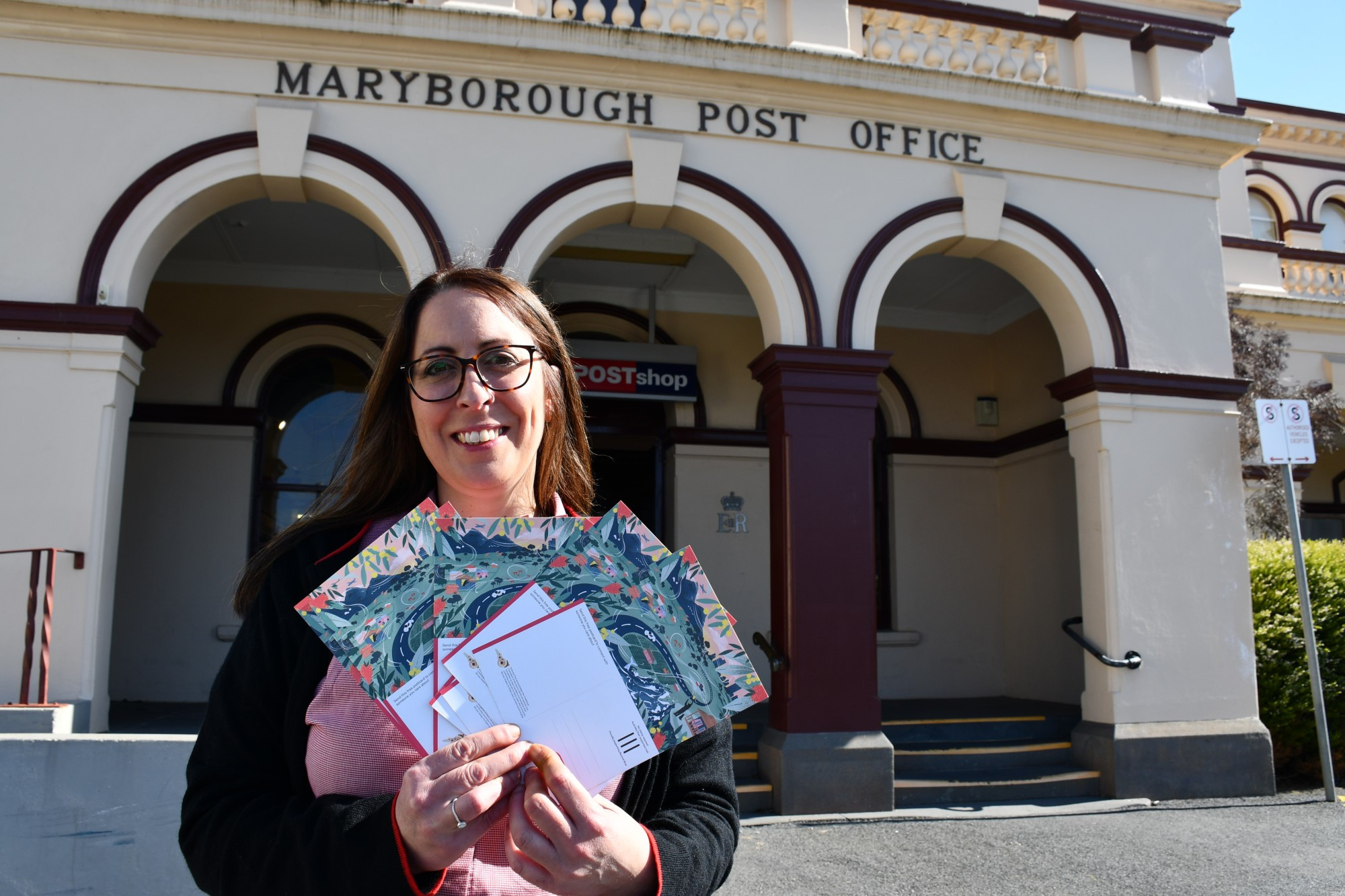 Maryborough Post Office postal service officer Rachel Millar with some of the free mental health cards now offered locally.