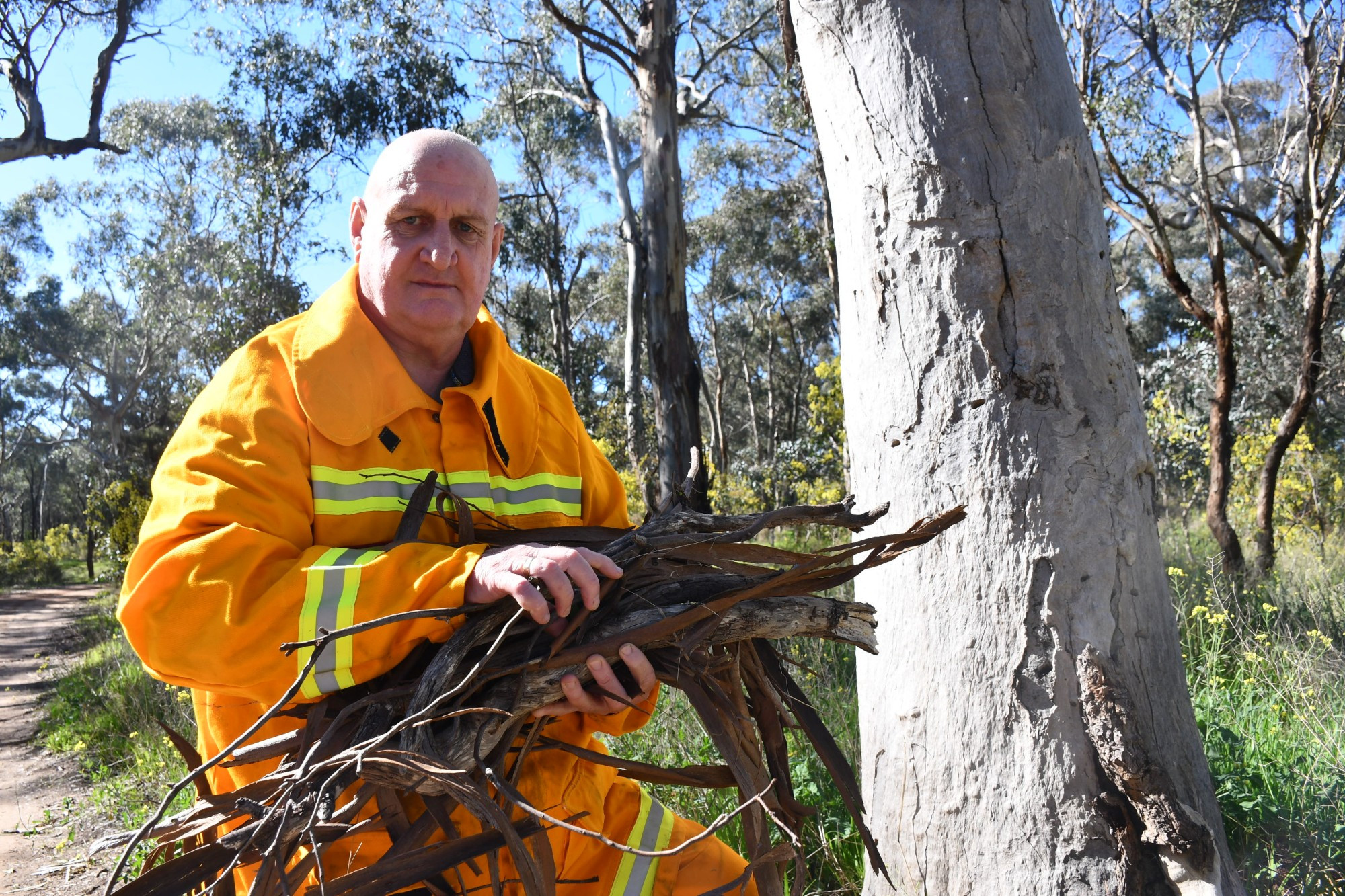 Carisbrook Fire Brigade Captain Ian Boucher is urging residents to start their fire prevention work now, showing the type of leaf litter they should be clearing from their properties. Photo: 150823 12