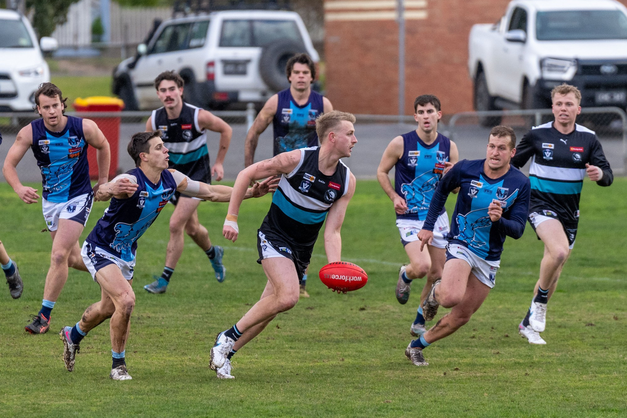 Mitch McClure burns off a couple of Eaglehawk opponents to get his handball away. Photo: 110723 12