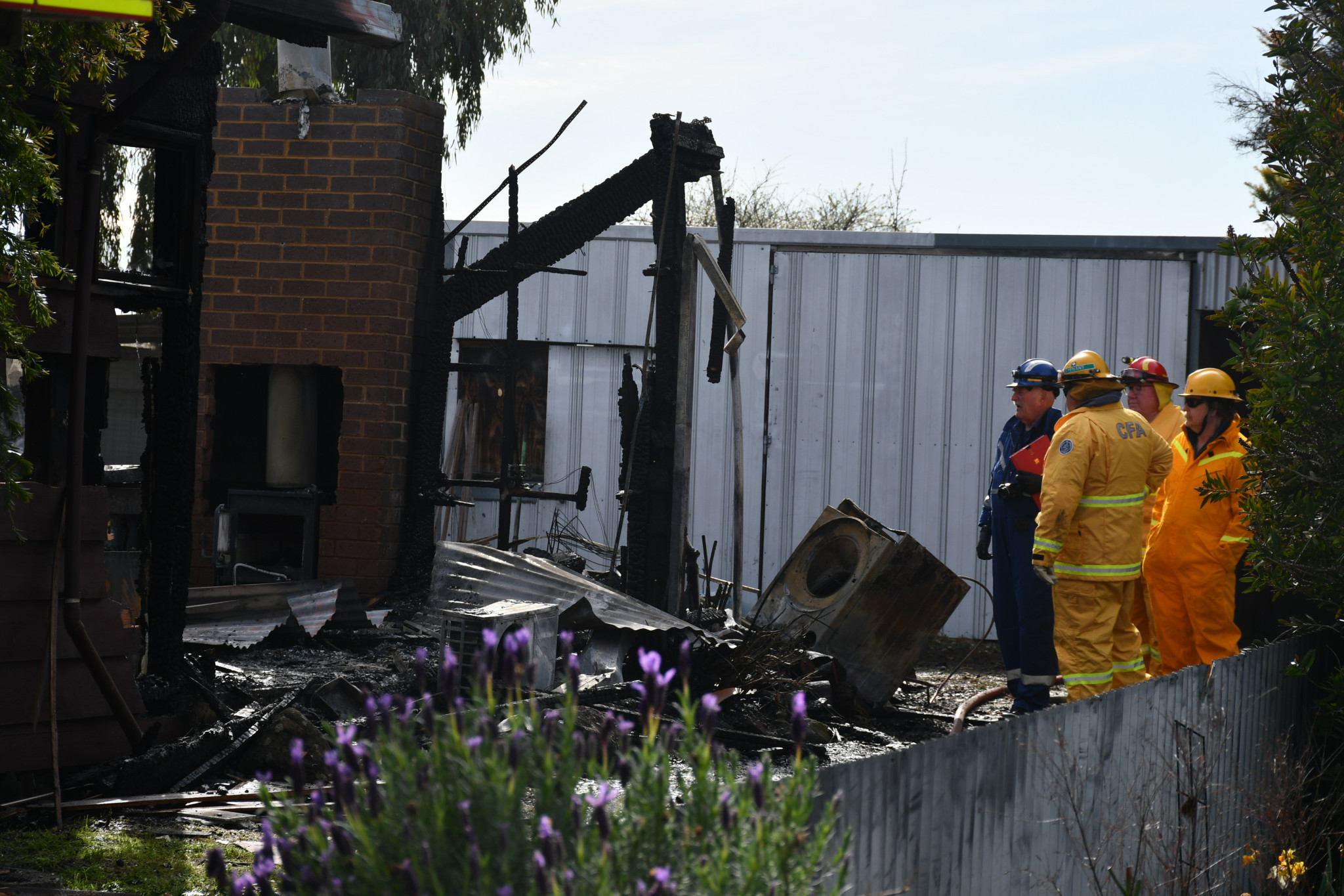 Local firefighters and a fire investigator surveyed the charred remains of a home in High Street as it was destroyed by flames Wednesday morning.