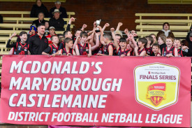 Carisbrook’s under 11.5 football premiers celebrate on the dais.