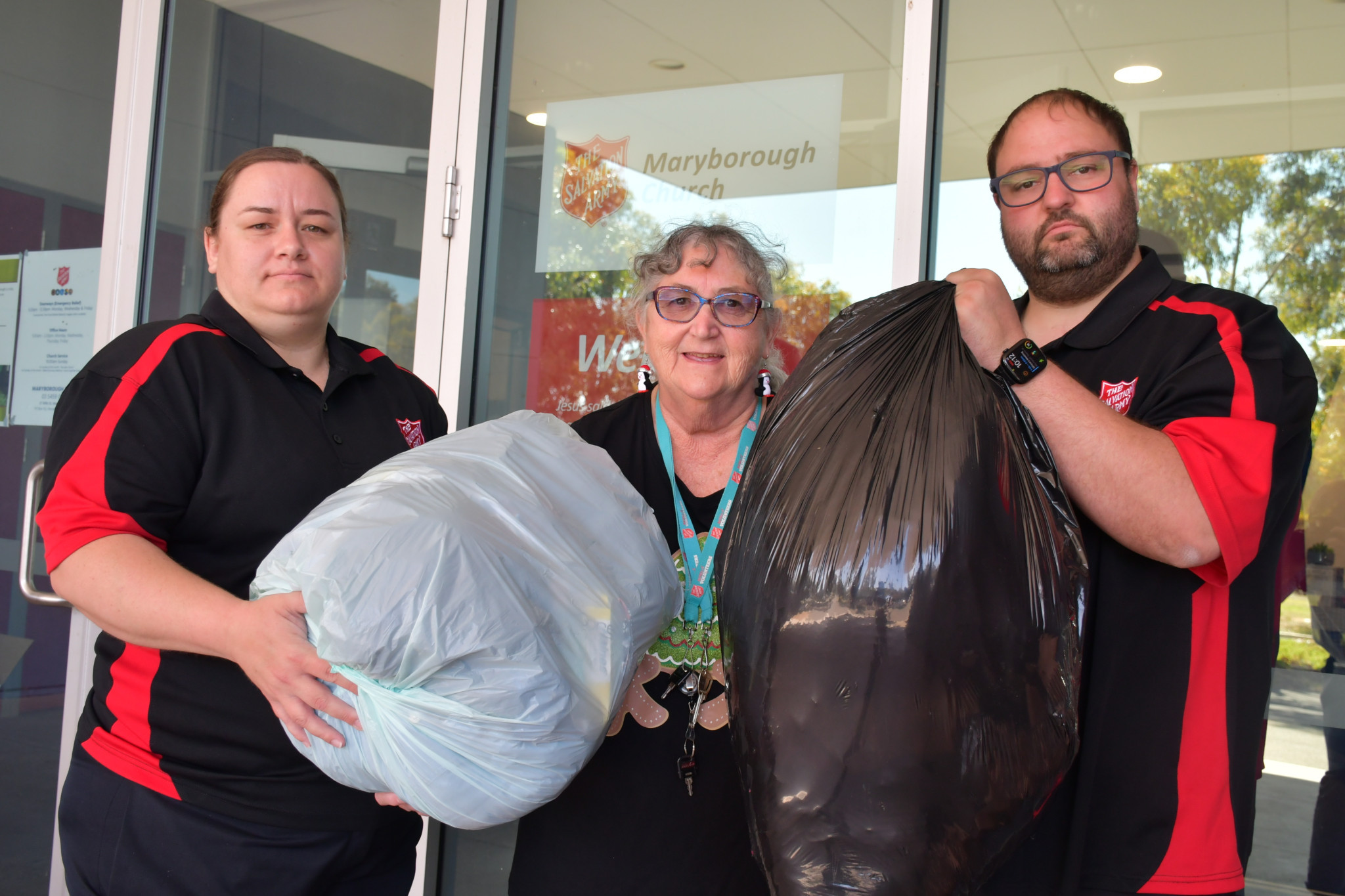 Maryborough Salvation Army members holding examples of dumped goods that have been left at the front of the Wills Street facility.