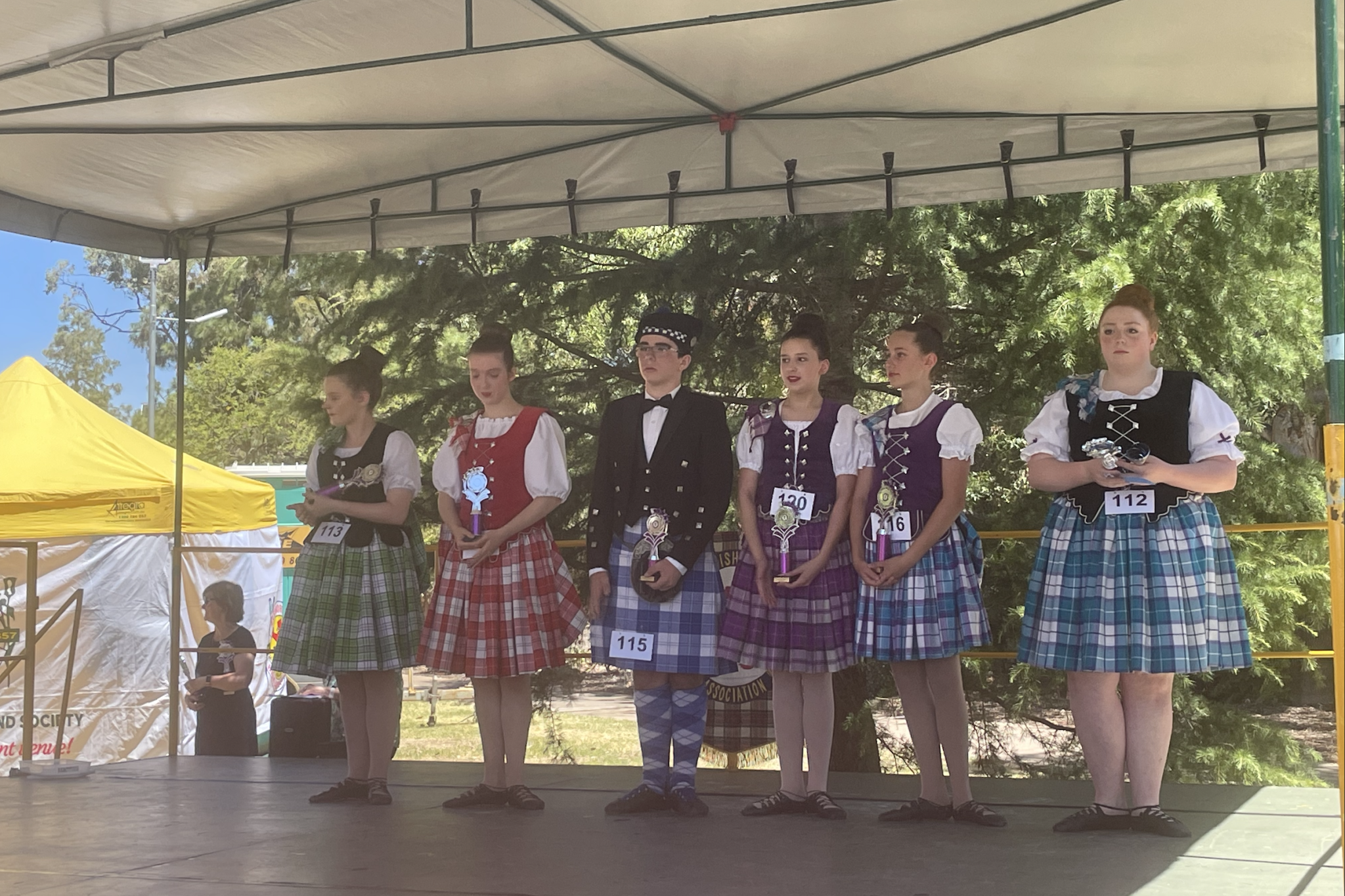 Highland dancers receiving their awards at the end of a hot summer day.