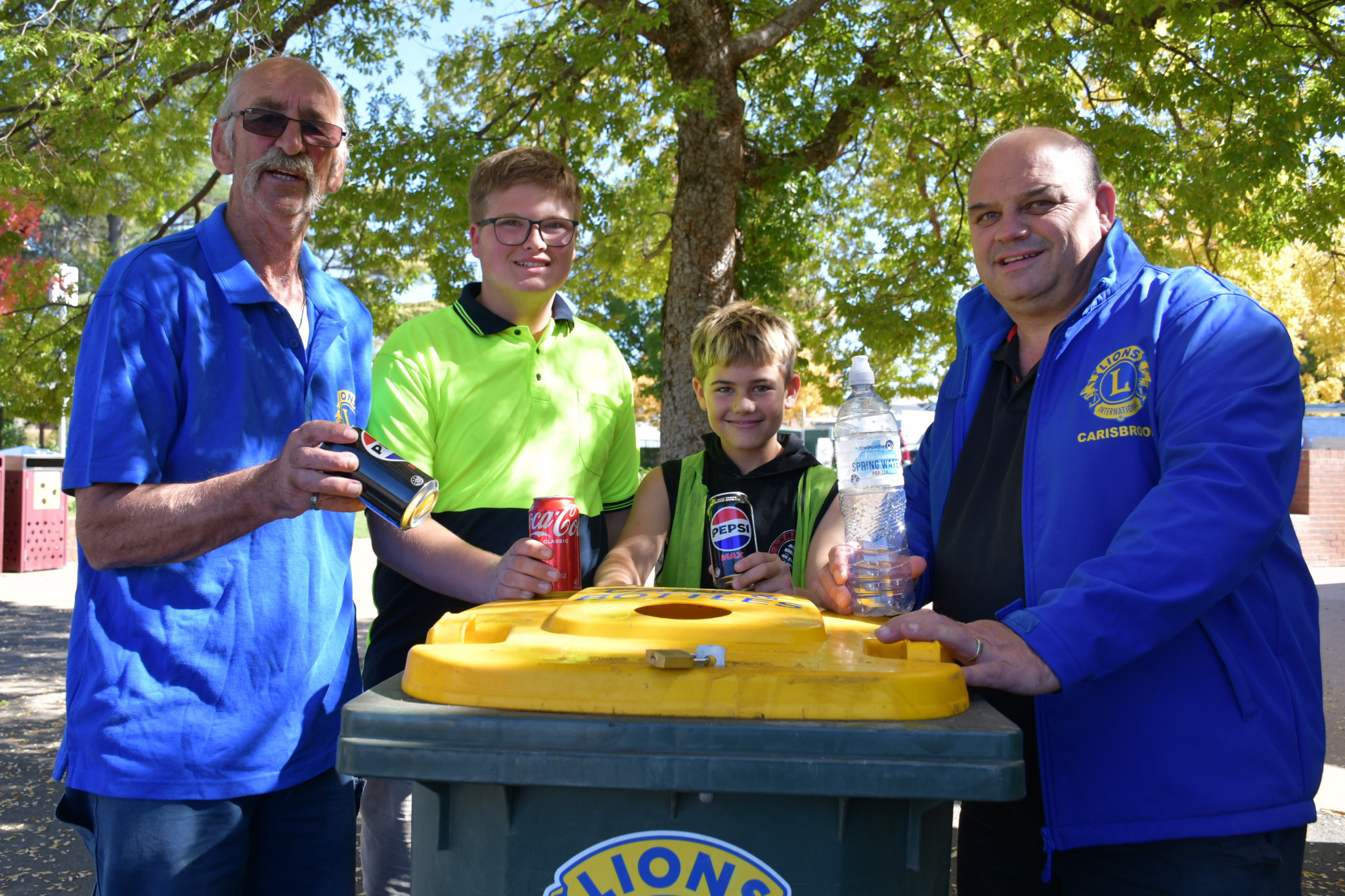 Graeme Johnson, Jeremy Parker, Jackson and Jefferson Hoober encourage everyone to use the Carisbrook Lions Club’s bins, which raise money that goes straight back into the community and helps the environment.