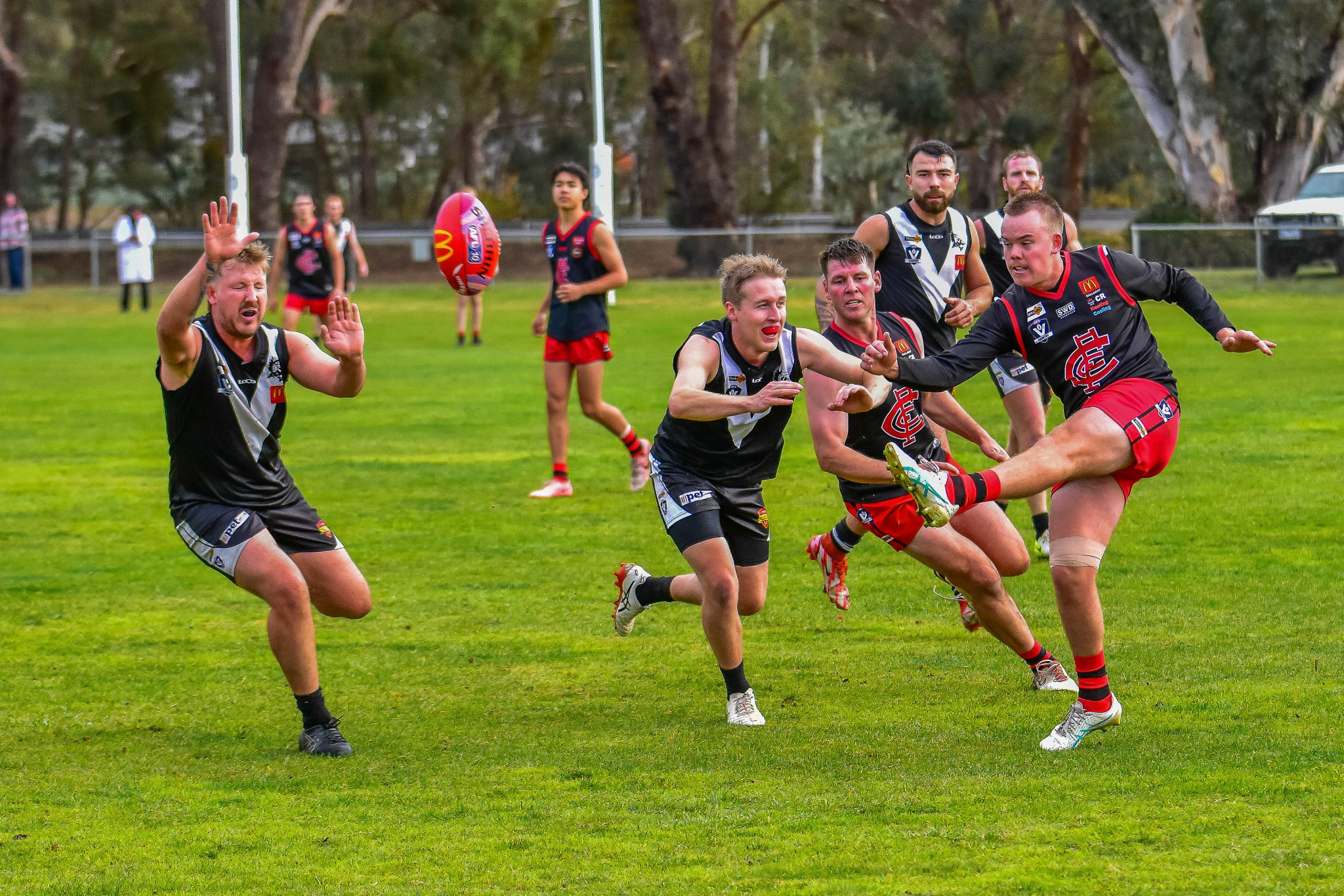 Lachlan Bursill kicks the ball forward for Carisbrook under serious pressure.
