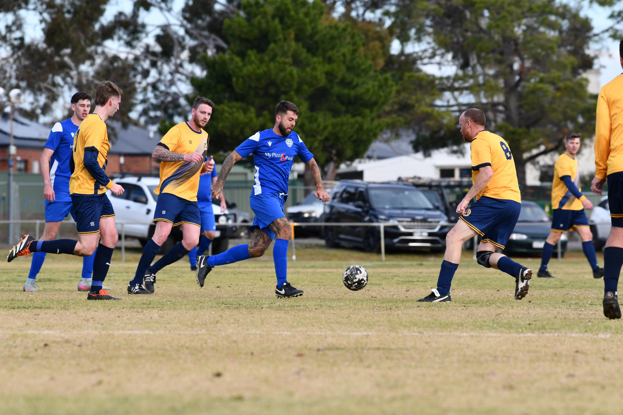 Brett Davey tries to dribble past a sea of Bacchus Marsh defenders.