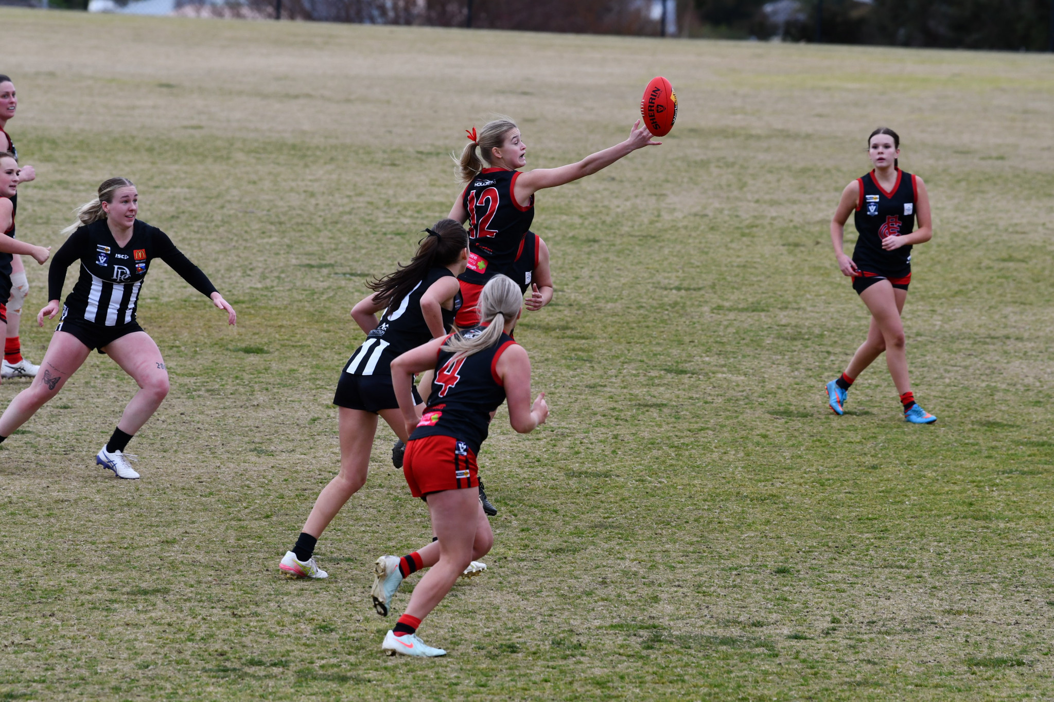 Lady Redbacks ruckman Emme Johnson taps the ball to advantage.
