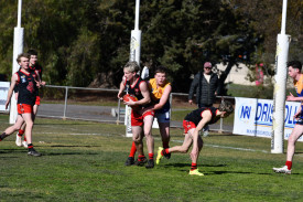 Carisbrook’s Noah Kerville tries to get a handball away while being tackled by Dunolly’s Christopher Potter in the under 17.5s.
