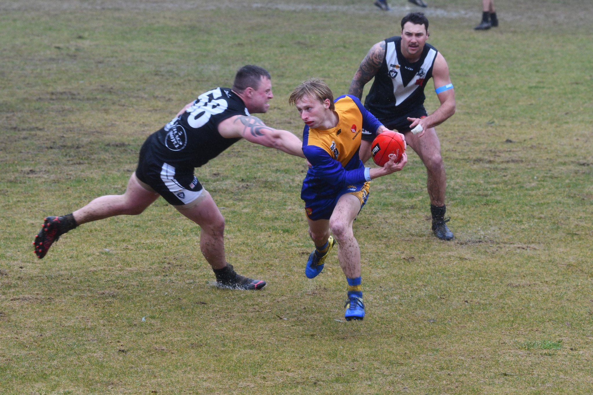 Harcourt’s Baxter Gurd evades the tackle of Campbells Creek’s Michael White.