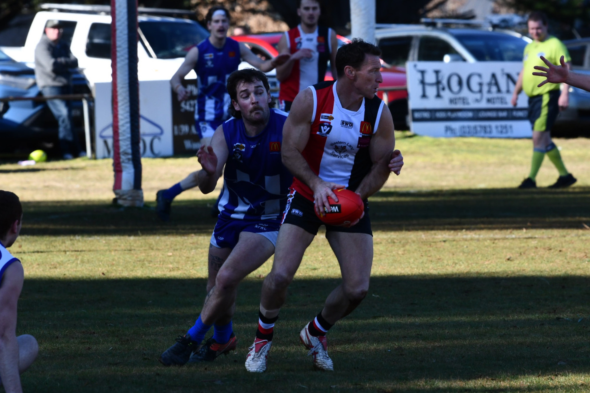 AFL Hall of Famer Brent Harvey tries to shake away from Harrison McGuire in Trentham’s 144-point demolition of Newstead, Harvey’s third game for the club.