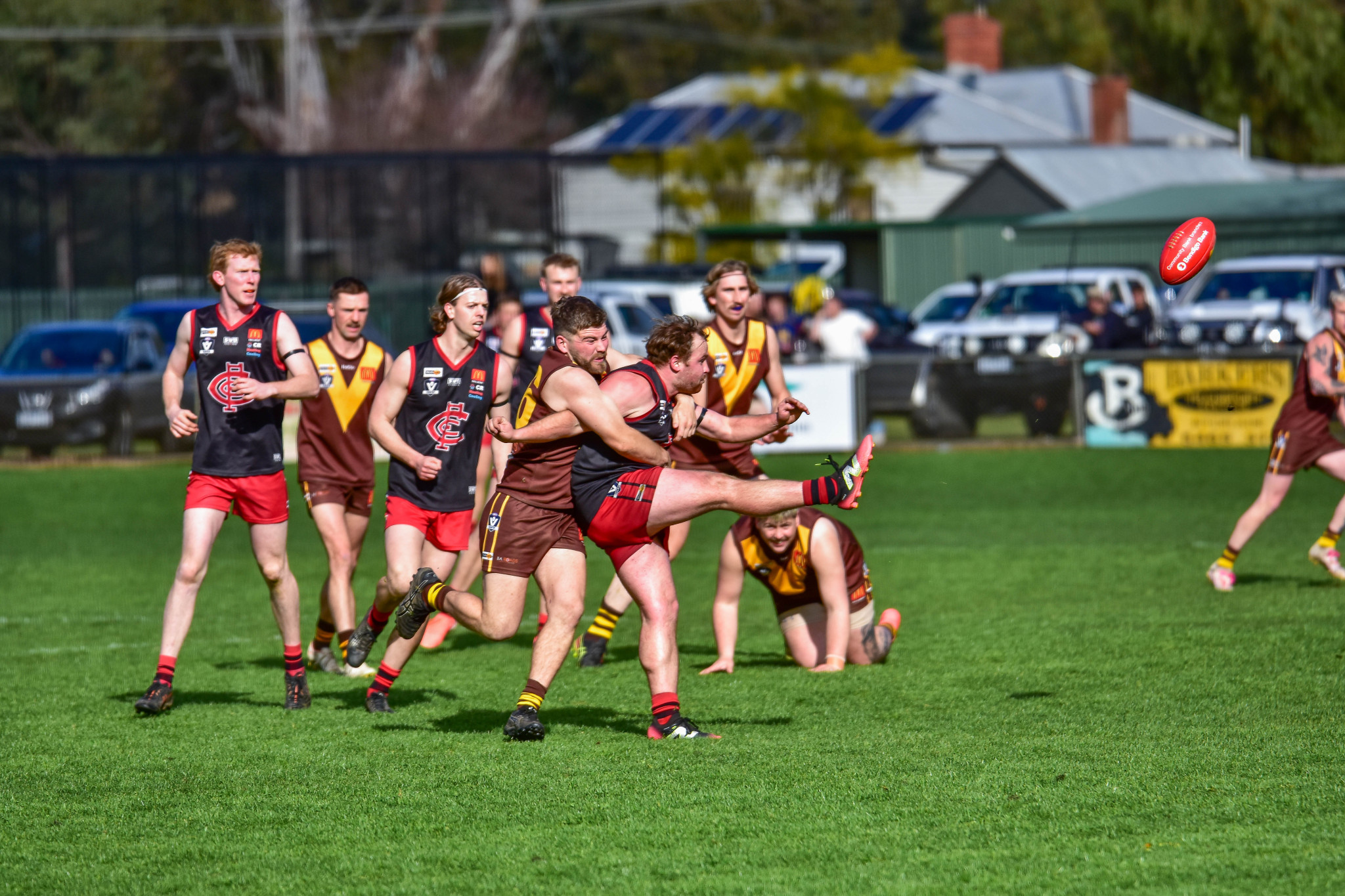 Patrick Van der Pol kicks the ball out of the gathering pack of Talbot players.